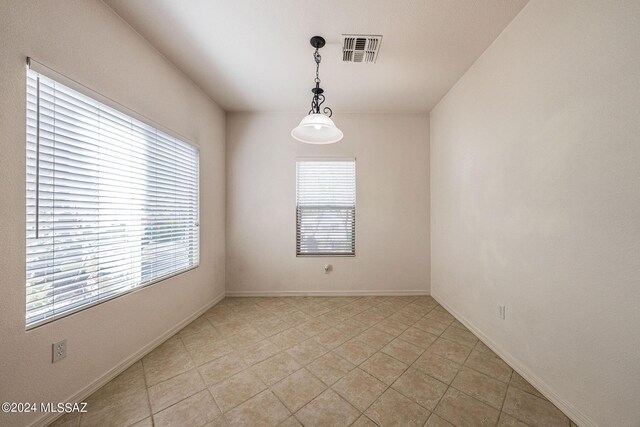 unfurnished room with light tile patterned floors and a healthy amount of sunlight