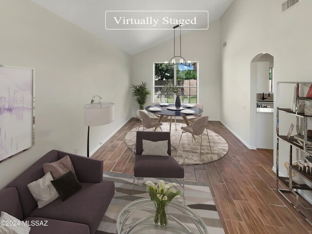 dining area featuring a chandelier, high vaulted ceiling, and dark hardwood / wood-style flooring