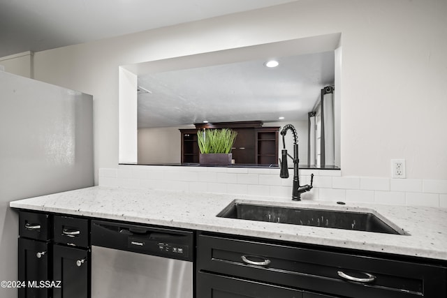 kitchen featuring light stone countertops, sink, and stainless steel dishwasher