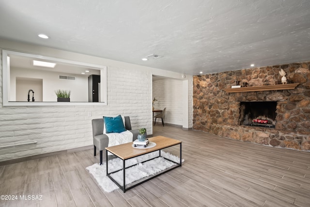 living room featuring a stone fireplace and hardwood / wood-style flooring