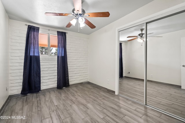 unfurnished bedroom with light hardwood / wood-style floors, a closet, and ceiling fan