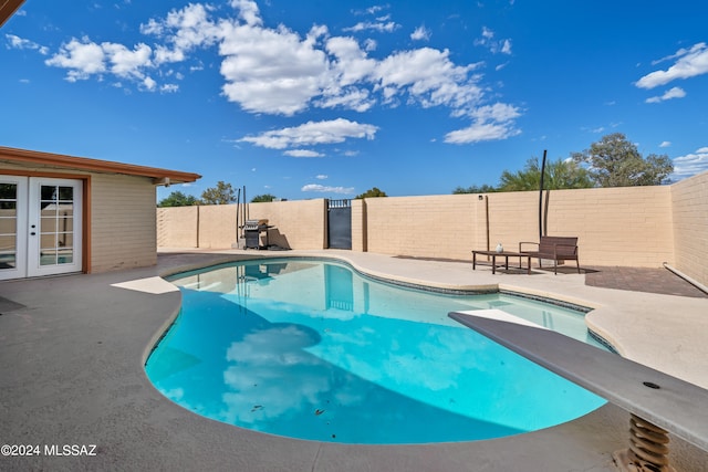 view of pool featuring a diving board and a patio area