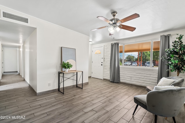 living area featuring light wood-type flooring and ceiling fan