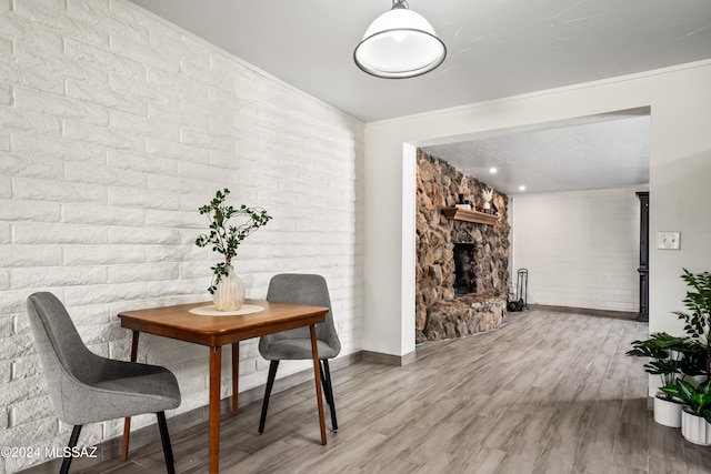 dining room featuring ornamental molding, hardwood / wood-style flooring, and a fireplace