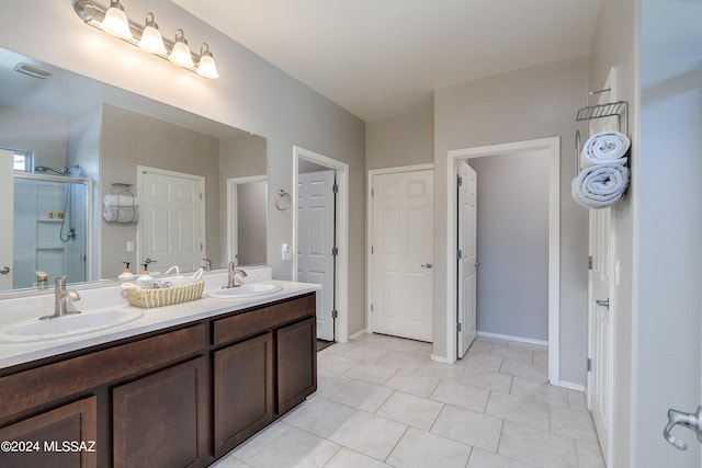 bathroom with tile patterned flooring, walk in shower, and vanity