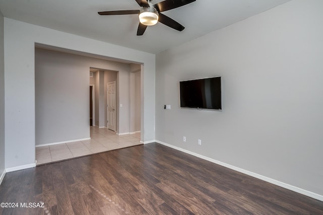 unfurnished living room featuring ceiling fan, baseboards, and wood finished floors