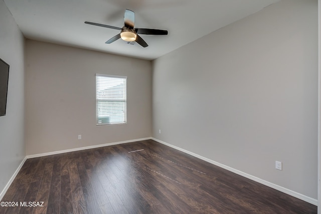 unfurnished room with ceiling fan, baseboards, and dark wood-type flooring