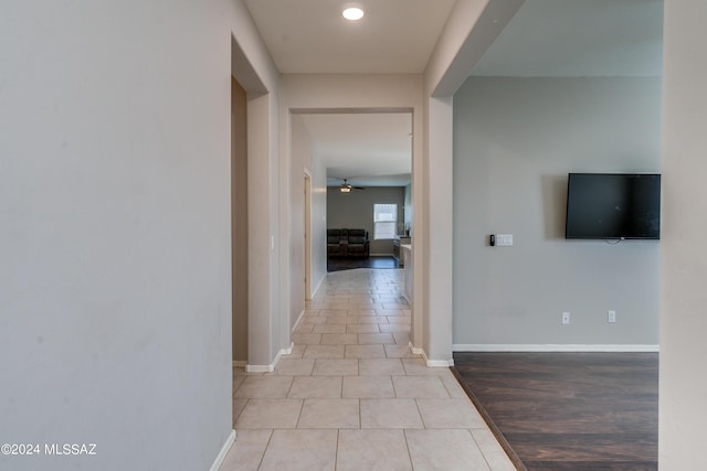 corridor featuring tile patterned flooring and baseboards