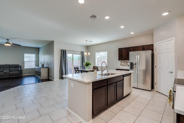 kitchen with visible vents, open floor plan, stainless steel appliances, dark brown cabinets, and a sink