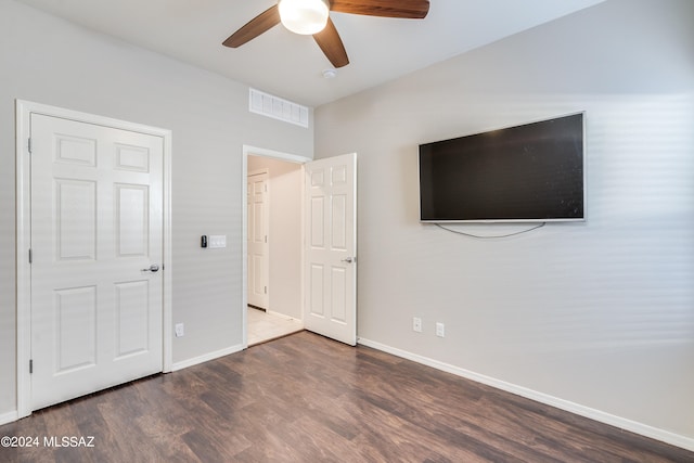 unfurnished bedroom featuring dark wood-type flooring and ceiling fan