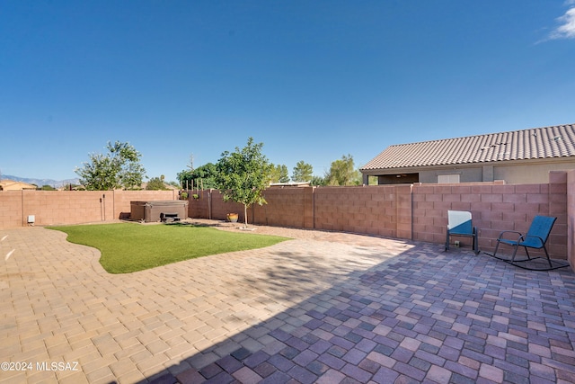 view of patio / terrace with a hot tub and a fenced backyard