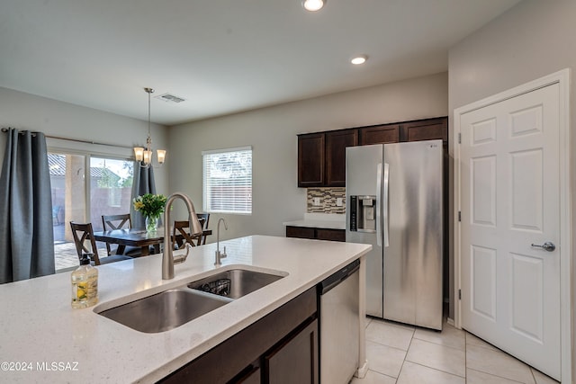 kitchen featuring visible vents, decorative light fixtures, stainless steel appliances, dark brown cabinets, and a sink