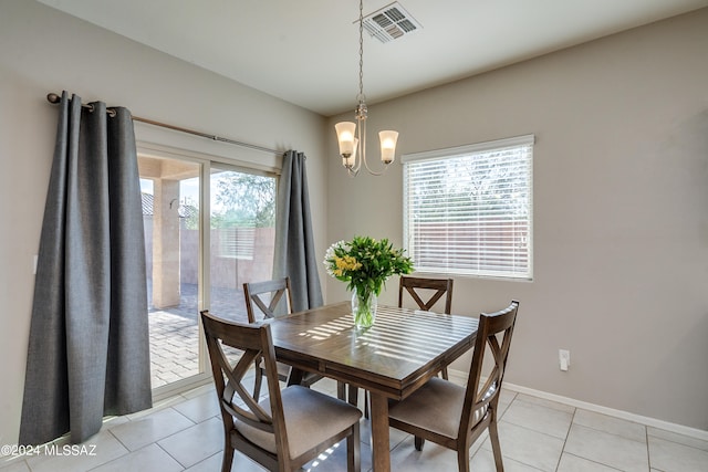 tiled dining room featuring an inviting chandelier