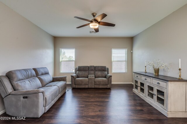 living room with dark hardwood / wood-style flooring, a wealth of natural light, and ceiling fan