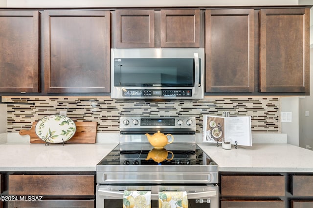 kitchen featuring stainless steel appliances, light stone countertops, dark brown cabinets, and tasteful backsplash