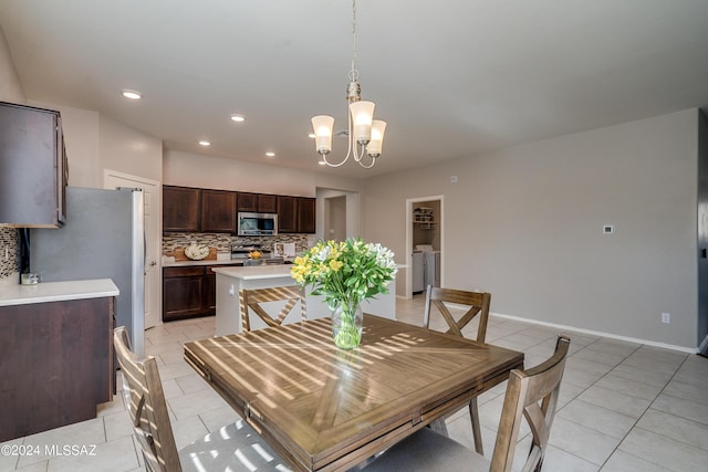 dining area featuring recessed lighting, a notable chandelier, washing machine and clothes dryer, and light tile patterned floors