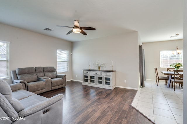 living room with a healthy amount of sunlight, ceiling fan with notable chandelier, and hardwood / wood-style flooring