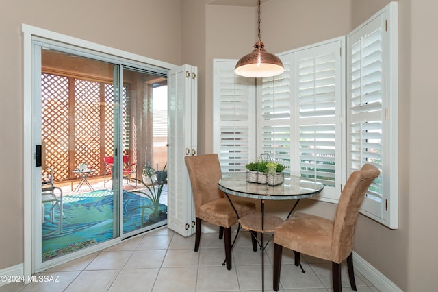 dining space featuring baseboards, plenty of natural light, and tile patterned flooring