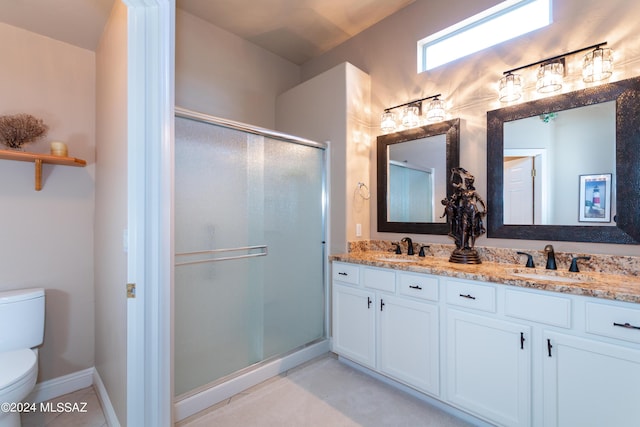 bathroom featuring a sink, toilet, a stall shower, and double vanity