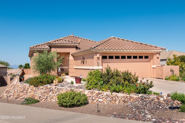 view of front of property with stucco siding, fence, concrete driveway, and a tiled roof