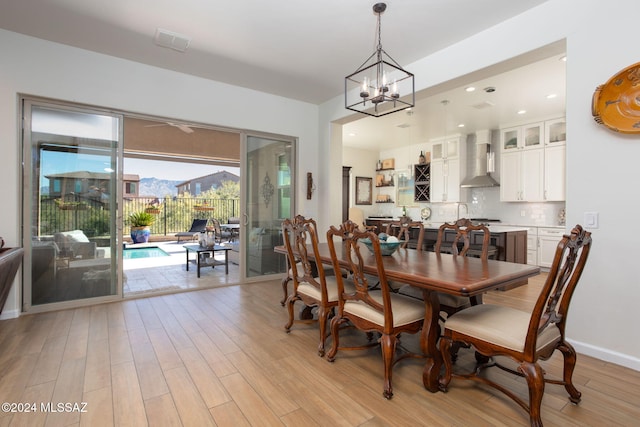 dining room with light wood-type flooring and an inviting chandelier