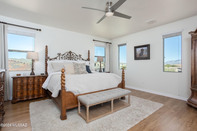 bedroom featuring multiple windows, light wood-type flooring, and ceiling fan