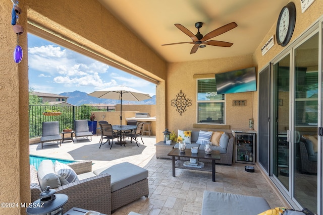 view of patio / terrace with ceiling fan, a fenced in pool, an outdoor hangout area, and beverage cooler