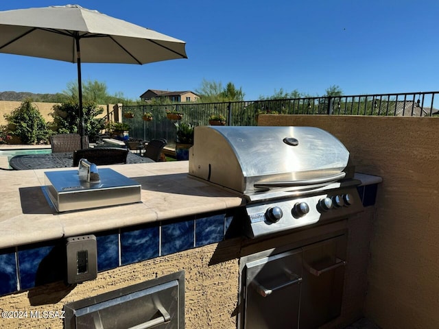 view of patio with area for grilling, grilling area, and a swimming pool