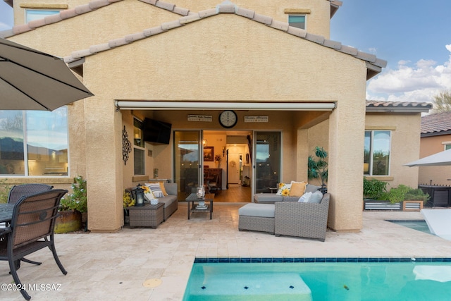 back of house with an outdoor living space and a patio