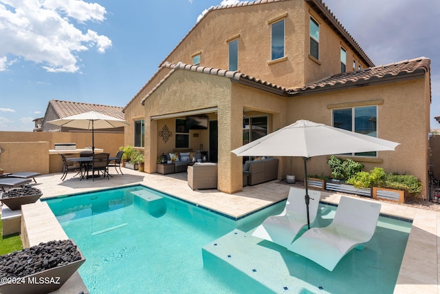 view of pool with an outdoor kitchen, an outdoor hangout area, and a patio