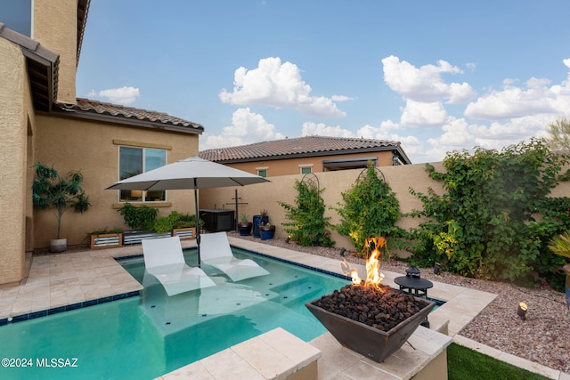 view of pool featuring a fire pit, central AC unit, and a patio area