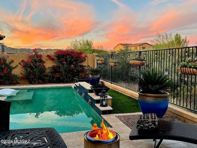 pool at dusk featuring pool water feature