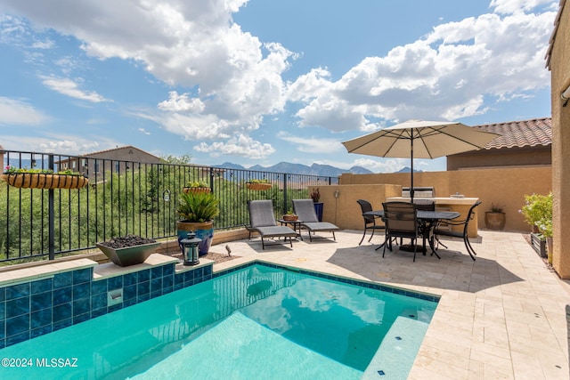 view of swimming pool with a mountain view and a patio area