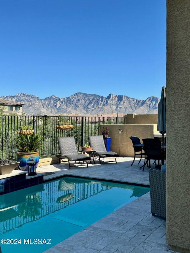 view of swimming pool featuring a mountain view and a patio