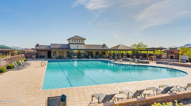 view of swimming pool featuring a fireplace and a patio