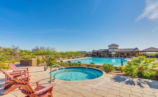 view of swimming pool featuring a patio area and a community hot tub