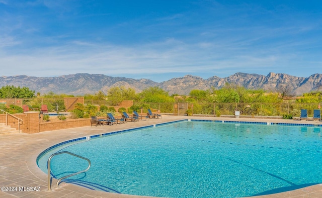 view of swimming pool with a mountain view and a patio area