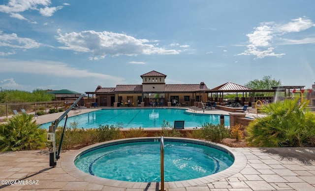 view of swimming pool featuring a patio area and a hot tub