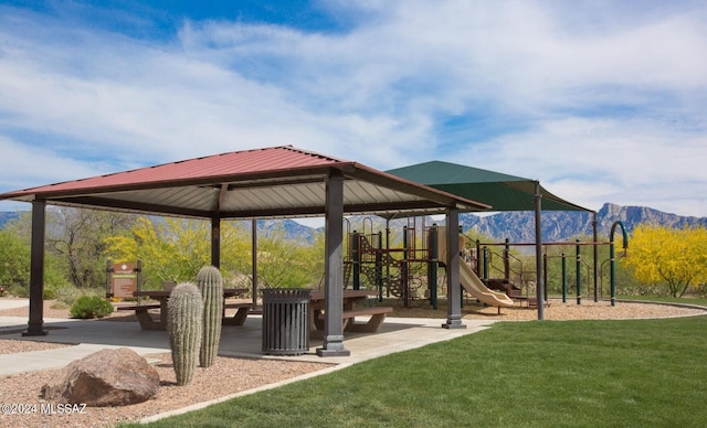 view of home's community featuring a lawn, a mountain view, and a playground