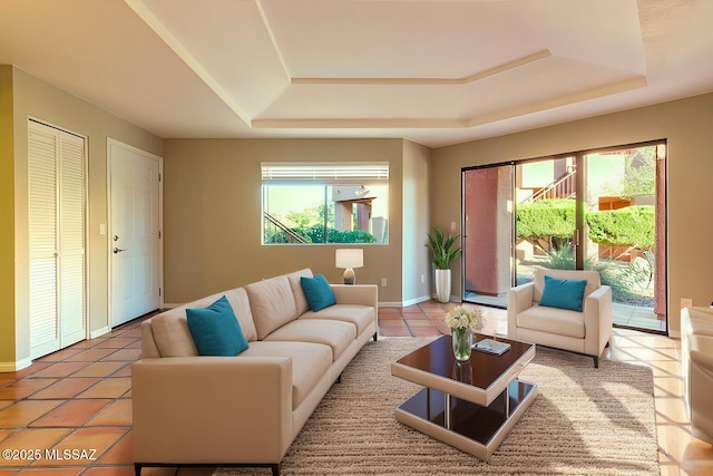 tiled living room with plenty of natural light and a tray ceiling