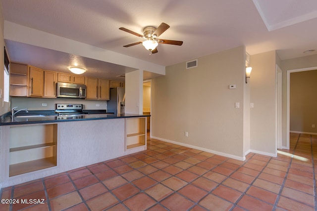 kitchen featuring ceiling fan, sink, stainless steel appliances, kitchen peninsula, and light brown cabinetry