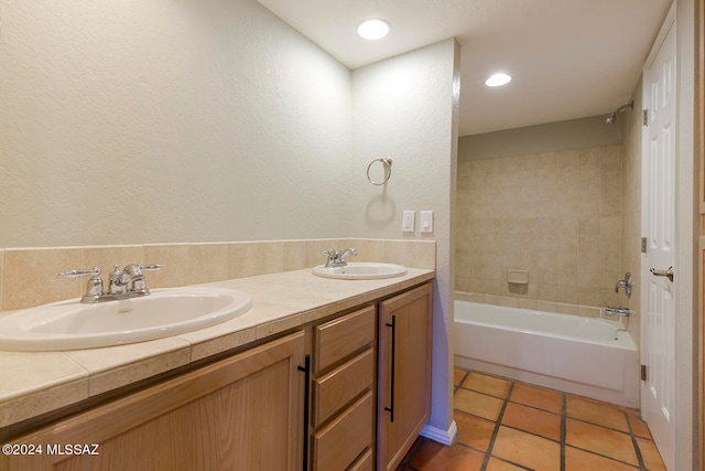 bathroom featuring tile patterned flooring, vanity, and tiled shower / bath