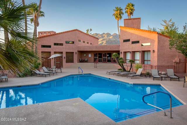 view of swimming pool featuring a mountain view and a patio