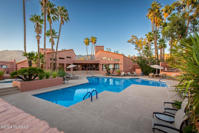 view of swimming pool with a mountain view and a patio