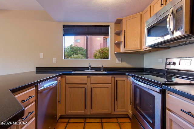 kitchen with sink, stainless steel appliances, and light tile patterned flooring