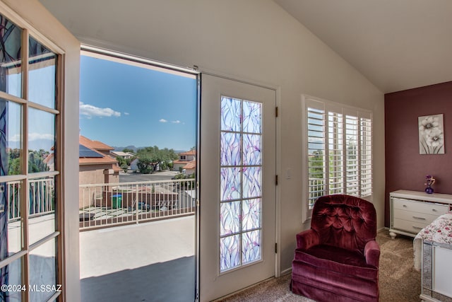 doorway to outside featuring lofted ceiling and carpet flooring