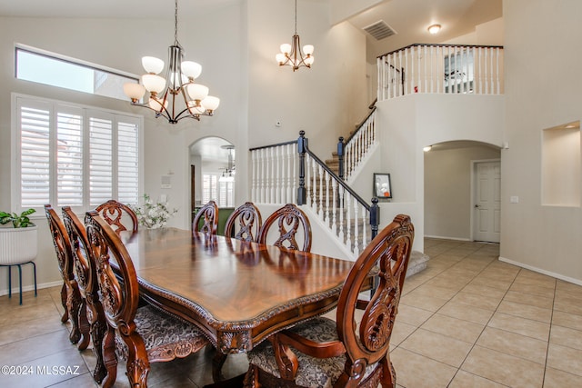 dining space featuring high vaulted ceiling, light tile patterned floors, and a notable chandelier