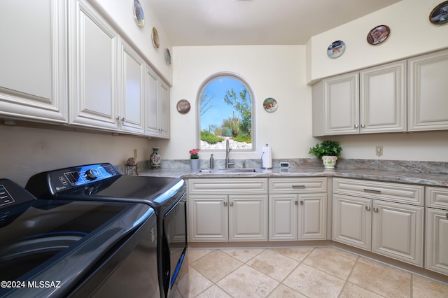 washroom with cabinets, sink, and washing machine and clothes dryer