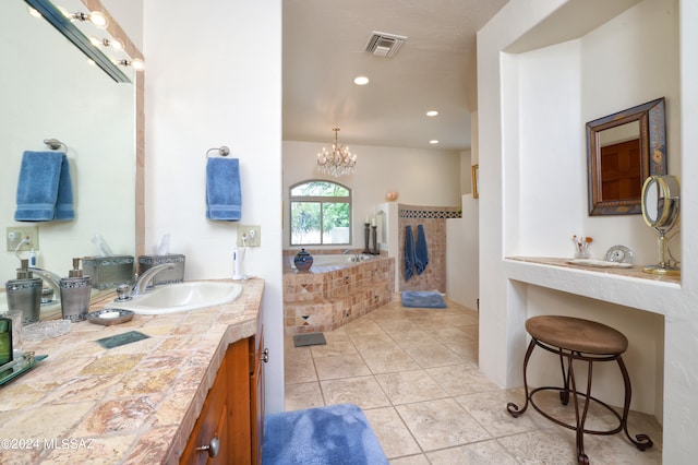 bathroom featuring an inviting chandelier, tiled tub, vanity, and tile patterned floors