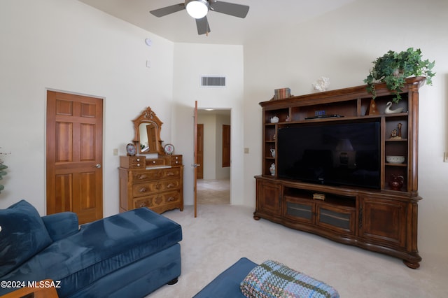 carpeted living room with a towering ceiling and ceiling fan